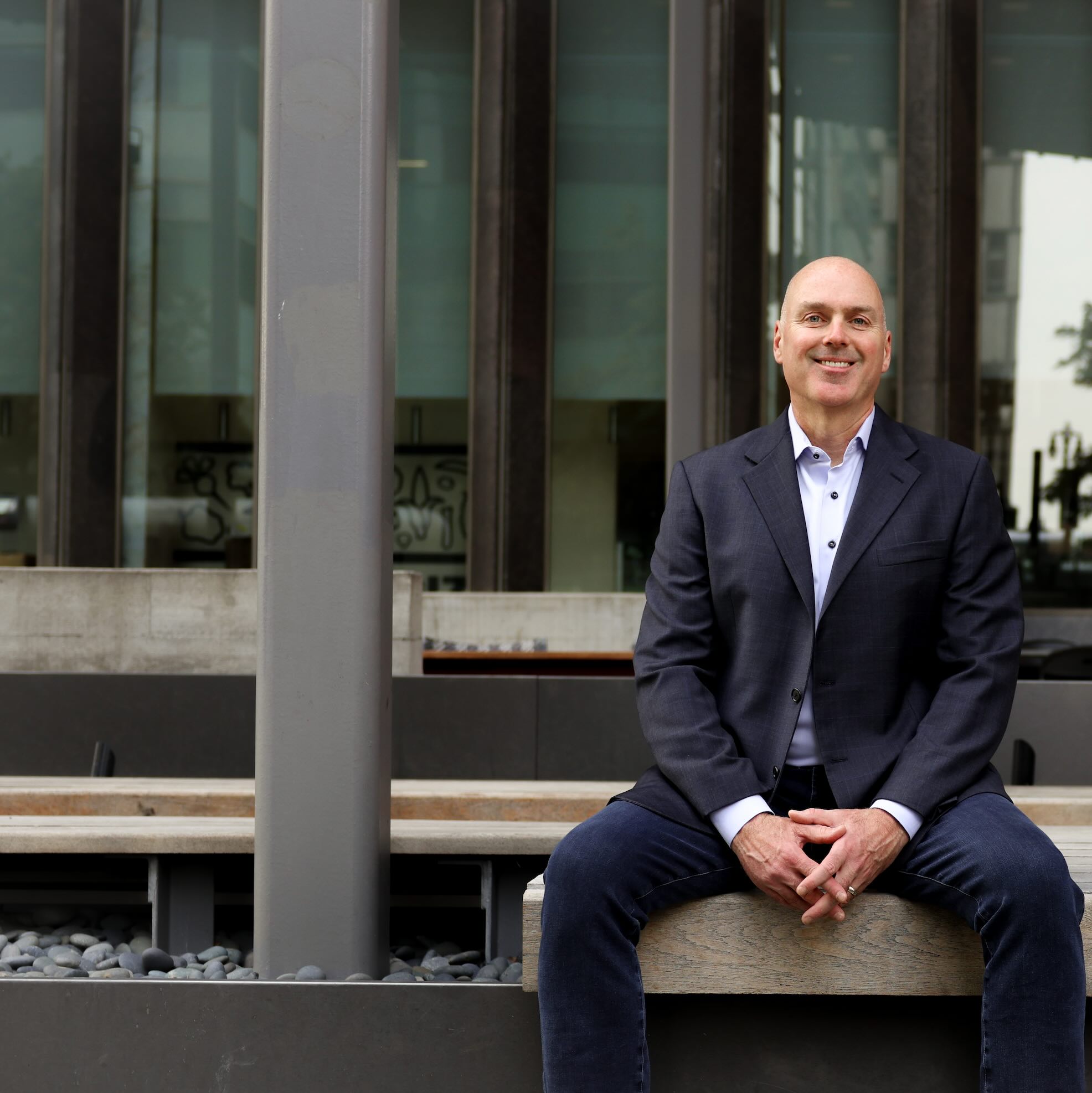 Bill Lethemon sitting outside in suit in front of building